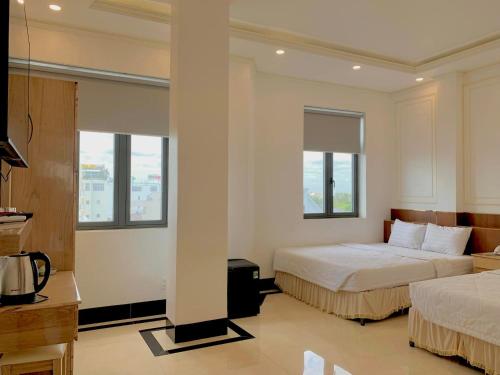 Habitación de hotel con 2 camas y 2 ventanas en Phụng Hoàng Vũ, en Bạc Liêu
