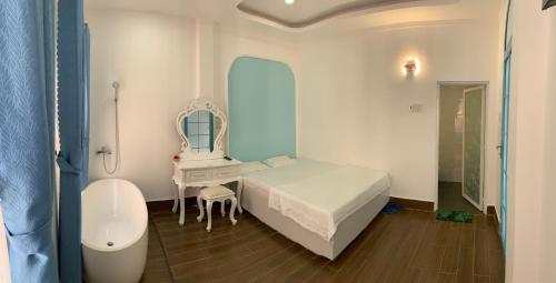 Hotel MAI TUAN Nguyễn Văn Linh في Phú Khương: غرفة نوم بسرير ومرآة ومغسلة