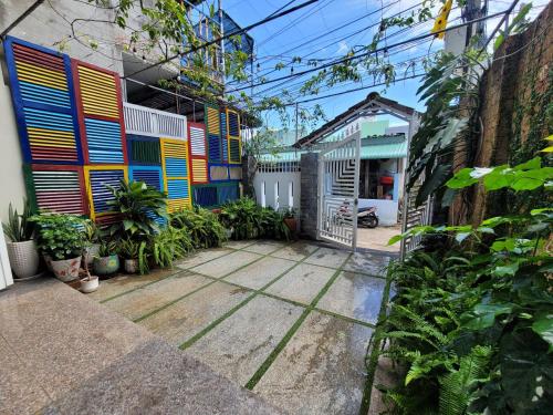 ein Gebäude mit bunten Türen und einem Innenhof mit Pflanzen in der Unterkunft Q House- Green Villa Quy Nhơn in Quy Nhon
