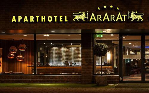 a sign on the front of a restaurant at night at Ararat All Suites Hotel Klaipeda in Klaipėda
