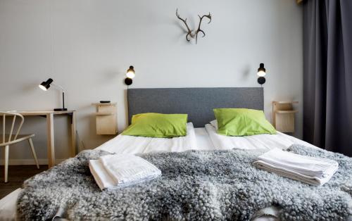 ein Schlafzimmer mit einem großen Bett mit grünen Kissen in der Unterkunft Camp Ripan in Kiruna