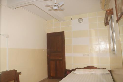 a bedroom with a bed and a ceiling fan at Amy's Hotel in Lomé