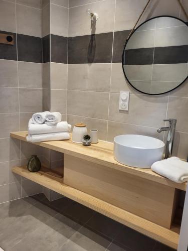 une salle de bain avec un lavabo, un miroir et des serviettes dans l'établissement Gîte Lomegaja 10 personnes proche Lascaux et Sarlat, à La Chapelle-Aubareil