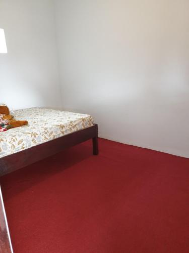 a bed in a room with a red carpet at Villa Pondok Dauh Saba in Tabanan