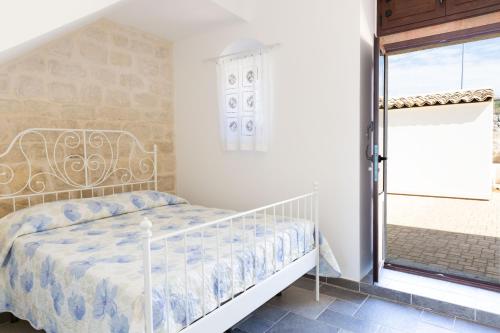Schlafzimmer mit einem Bett und einem Fenster in der Unterkunft emozioni di casa Barone in Scicli