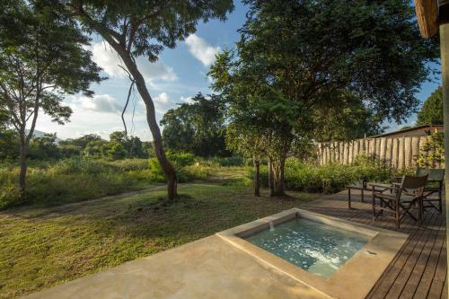 a swimming pool in a yard with a table and chairs at Ceylon Wild in Kataragama