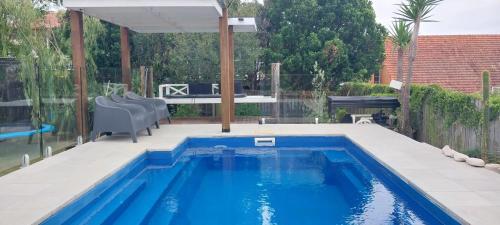 a swimming pool in the backyard of a house at Maple Villa - The Beach House by the bay in Brisbane