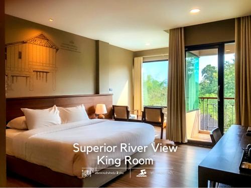 a bedroom with a king bed and a large window at River Tree Resort in Chiang Khan
