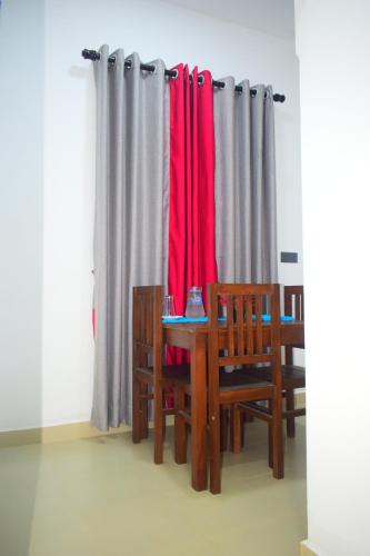 um quarto com uma mesa, cadeiras e cortinas em Eleven11 Resort em Anuradhapura