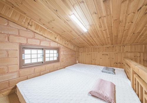 a bedroom with a bed in a brick wall at Jeju Healing Resort in Jeju