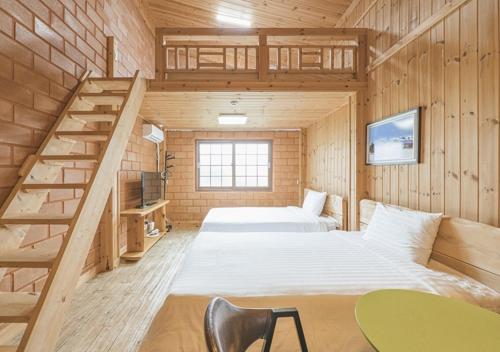 a bedroom with two beds and a staircase at Jeju Healing Resort in Jeju