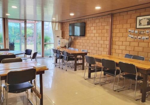 a dining room with wooden tables and chairs at Jeju Healing Resort in Jeju