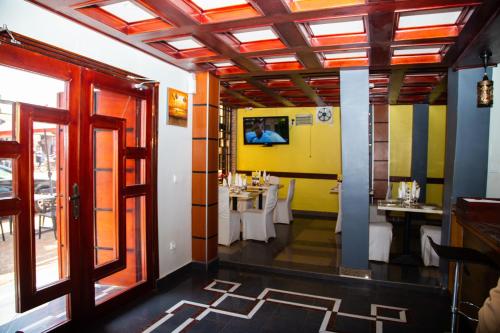 Hotel Le Kremlin Yaoundé في ياوندي: مطعم فيه طاولات وكراسي في الغرفة