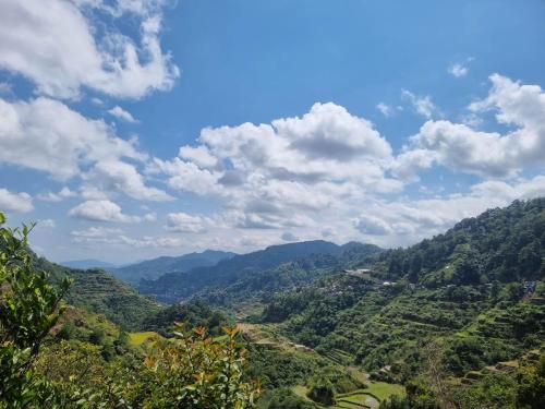 een uitzicht op een vallei met bergen en bossen bij Rita's Homestay in Talap