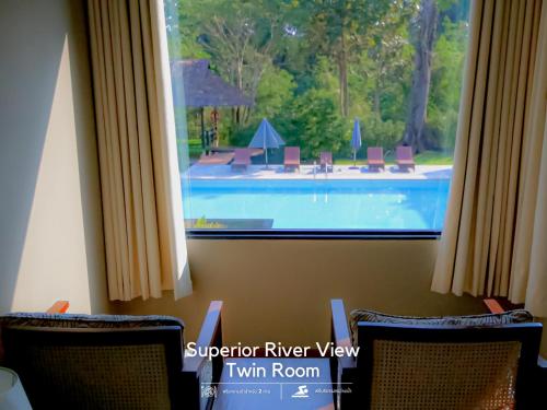 a view of a swimming pool through a window at River Tree Resort in Chiang Khan