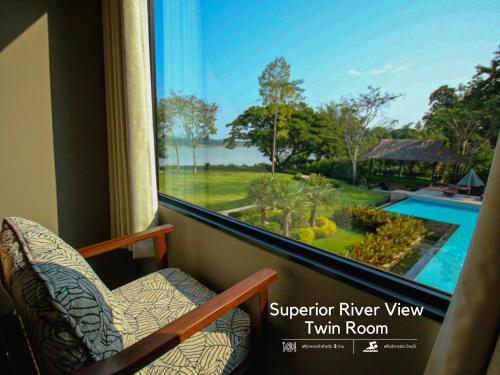 a room with a window with a view of a pool at River Tree Resort in Chiang Khan