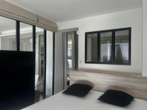 a bedroom with a bed with two pillows and a mirror at LE PANORAMIQUE, P2 vue sur mer, clim, centre ville, WIFI in La Grande-Motte