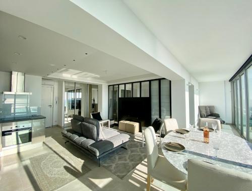a living room with a table and a couch at LE PANORAMIQUE, P2 vue sur mer, clim, centre ville, WIFI in La Grande-Motte