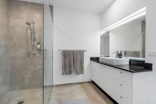 a bathroom with a glass shower and a sink at Sunset Seaside Sanctuary in Mornington