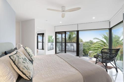 a bedroom with a large bed and a balcony at Sunset Seaside Sanctuary in Mornington