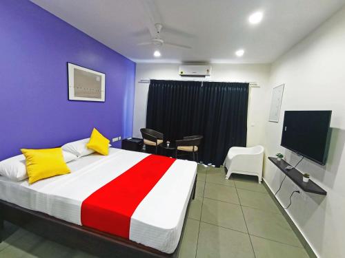 1 dormitorio con 1 cama grande y TV en STAYMAKER White Sand Beach Resort en Honāvar