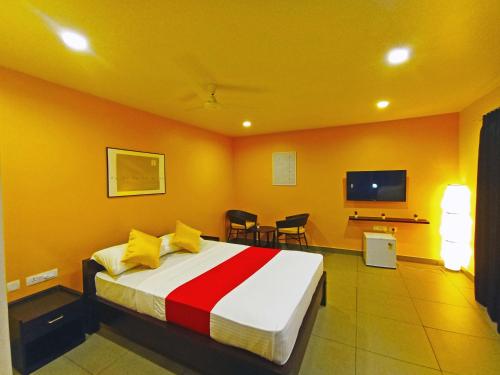 a hotel room with a bed and a tv at STAYMAKER White Sand Beach Resort in Honāvar