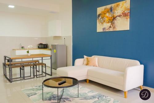 a living room with a white couch and a table at COZY Bali Residence Apartment NEARBY KLEBANG BEACH in Tranquerah