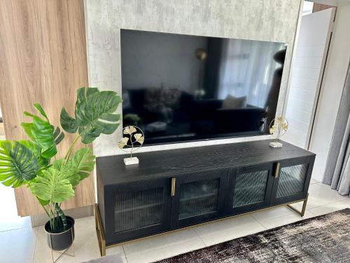 a black entertainment center with a large flat screen tv at M Luxury Home In Irene Centurion-No Blackouts in Centurion
