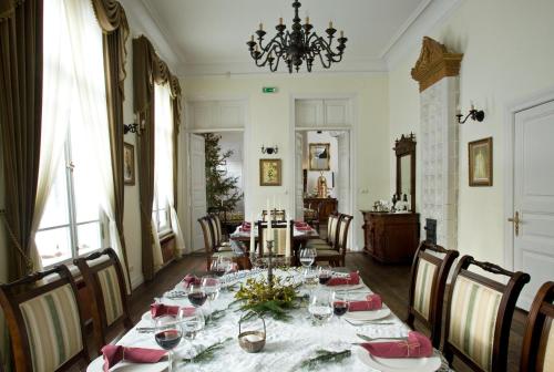 a dining room with a long table with wine glasses at Apartamenty Carskie in Białowieża