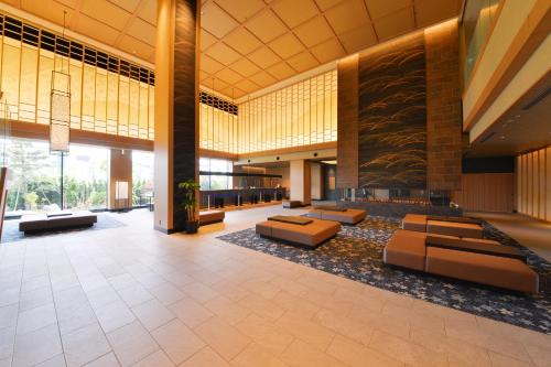 un hall avec des canapés et des tables dans un bâtiment dans l'établissement Hakodate Yunokawa Onsen Umi to Akari Hewitt Resort, à Hakodate
