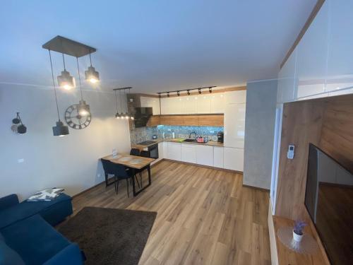 ein Wohnzimmer mit einem blauen Sofa und einer Küche in der Unterkunft Apartament Calisia in Kalisz