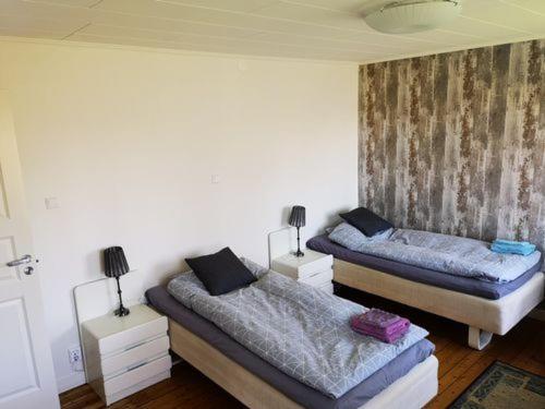 2 łóżka pojedyncze w pokoju z 2 lampami w obiekcie Falkenberg /Vinberg w mieście Vinberg