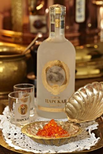a bottle of whiskey and a plate of food on a table at Apartamenty Carskie in Białowieża