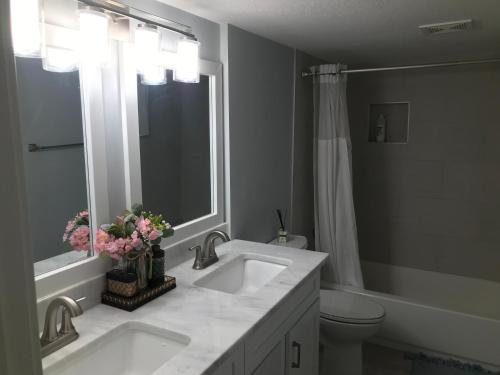 a bathroom with two sinks and a toilet and a mirror at Sweet Dreams in South Jordan