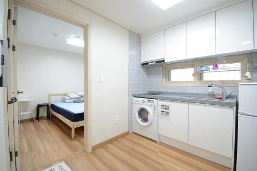 a kitchen with a washer and dryer in a room at Sunnyhill Guesthouse Hongdae in Seoul