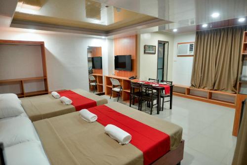 een hotelkamer met 2 bedden en een eetkamer bij FLOROTEL II in General Santos