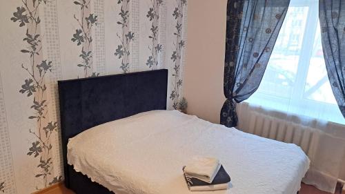 a bedroom with a bed with a black headboard and a window at Teatra 32 in Daugavpils