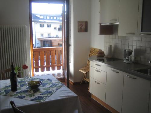 a small kitchen with a table and a balcony at Schlernheim Apartment in Völs am Schlern