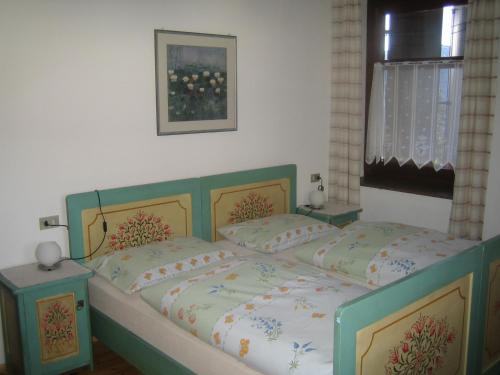 a bedroom with a green bed with two pillows at Schlernheim Apartment in Völs am Schlern