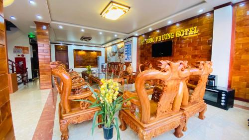 un restaurante con sillas de madera y una mesa con flores en HỒNG PHƯƠNG HOTEL, en Cao Bằng