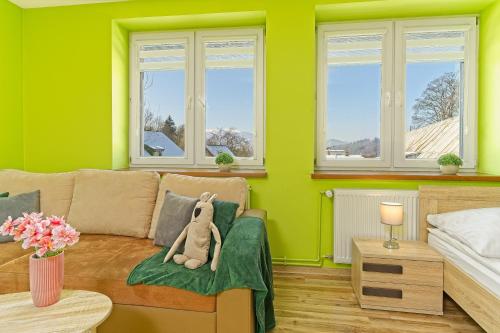 科瓦雷的住宿－Domek Wojków - Kowary koło Karpacza，客厅设有绿色的墙壁和一张带泰迪熊的沙发