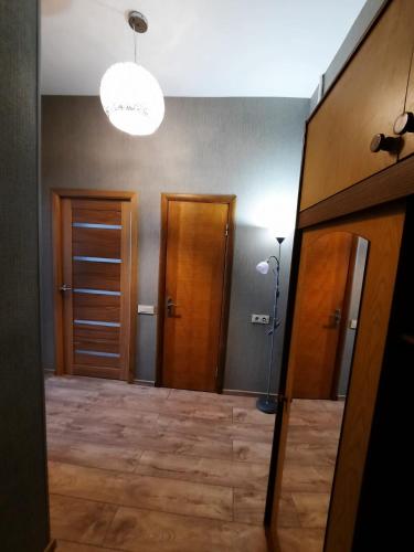 a hallway with two wooden doors and a light at Rigas 72 in Daugavpils
