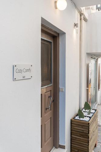 a door to a white building with a sign that reads grey countynan at Cozy Comfy Town House in Naxos Chora