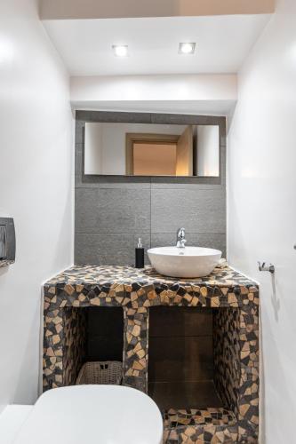 a bathroom with a sink and a mirror at Cozy Comfy Town House in Naxos Chora