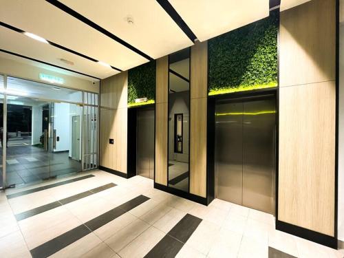 un pasillo de un edificio con plantas en las paredes en SK Homestay Seremban 2 en Seremban