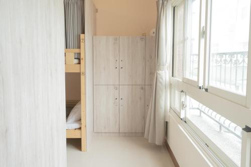 a small bedroom with a bunk bed and a window at Manas B&B in Taitung City