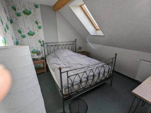 a small bedroom with a bed in a attic at Altmark - Haus am Hang mit Garten in Dähre