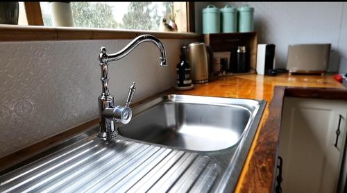 a stainless steel kitchen sink with a faucet at Baroona Cottage in Barwite