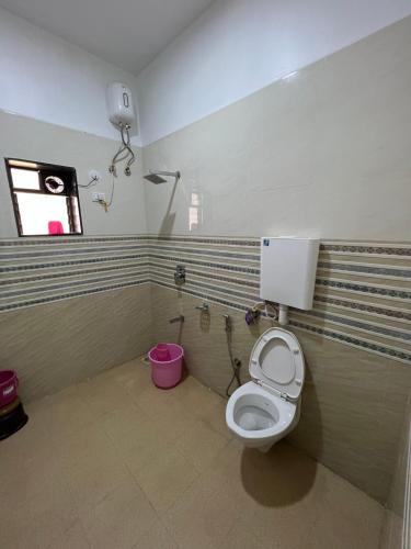 a bathroom with a toilet and a window at iIRA Stays: Ocean Bliss (Sea View) in Alibaug