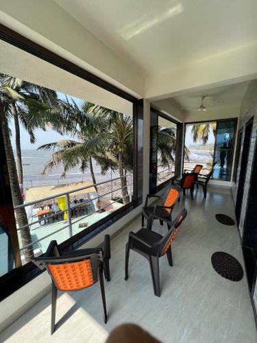 a balcony with chairs and a view of the beach at iIRA Stays: Ocean Bliss (Sea View) in Alibaug